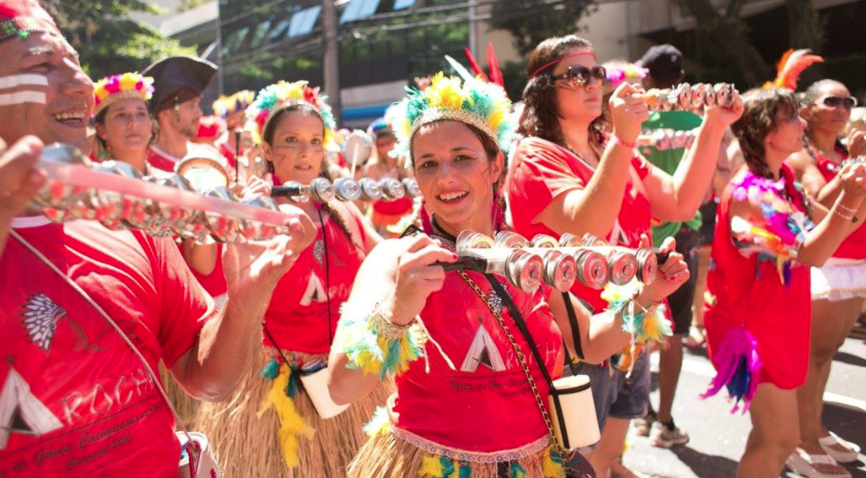 Bateria do bloco vestidos de índio passando no meio da rua